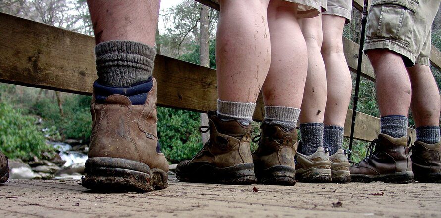 a group of people wearing different hiking shoes and boots