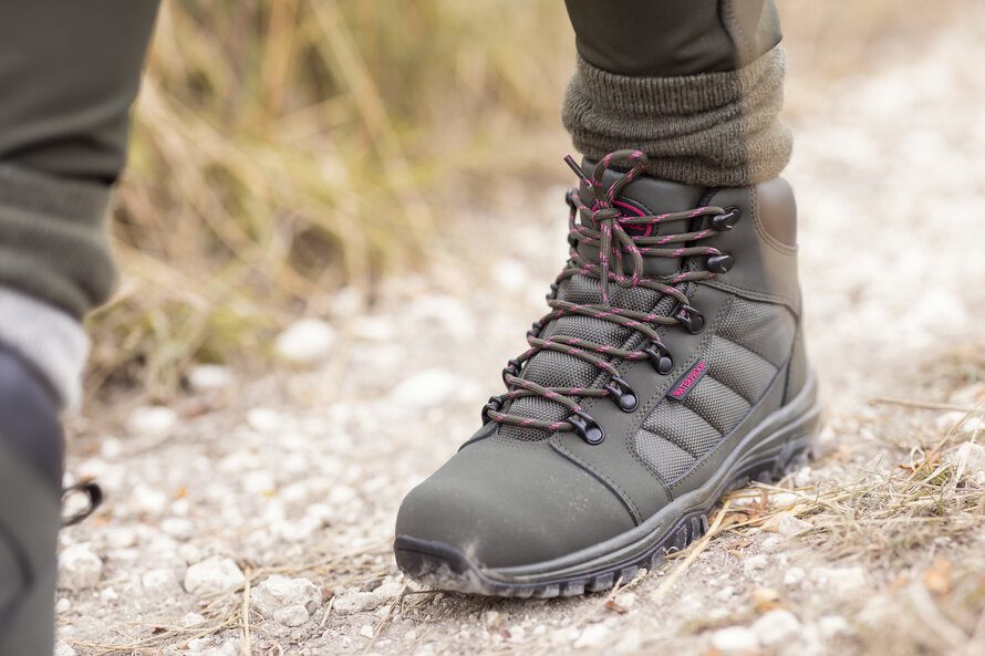 closeup of hiking boots of a person hiking on a trail
