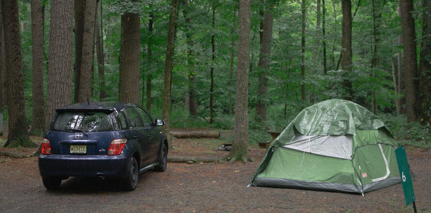 car and tent in the woods