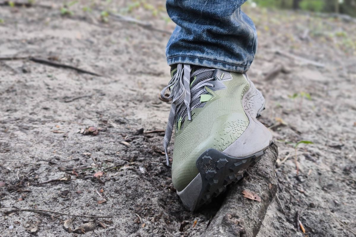 Do You Need Ankle Support for Hiking? (What You Must Know) Trail runner stepping over a tree root on uneven hiking terrain