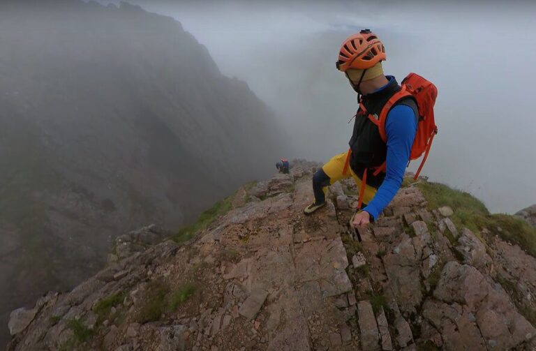 person scrambling a mountain