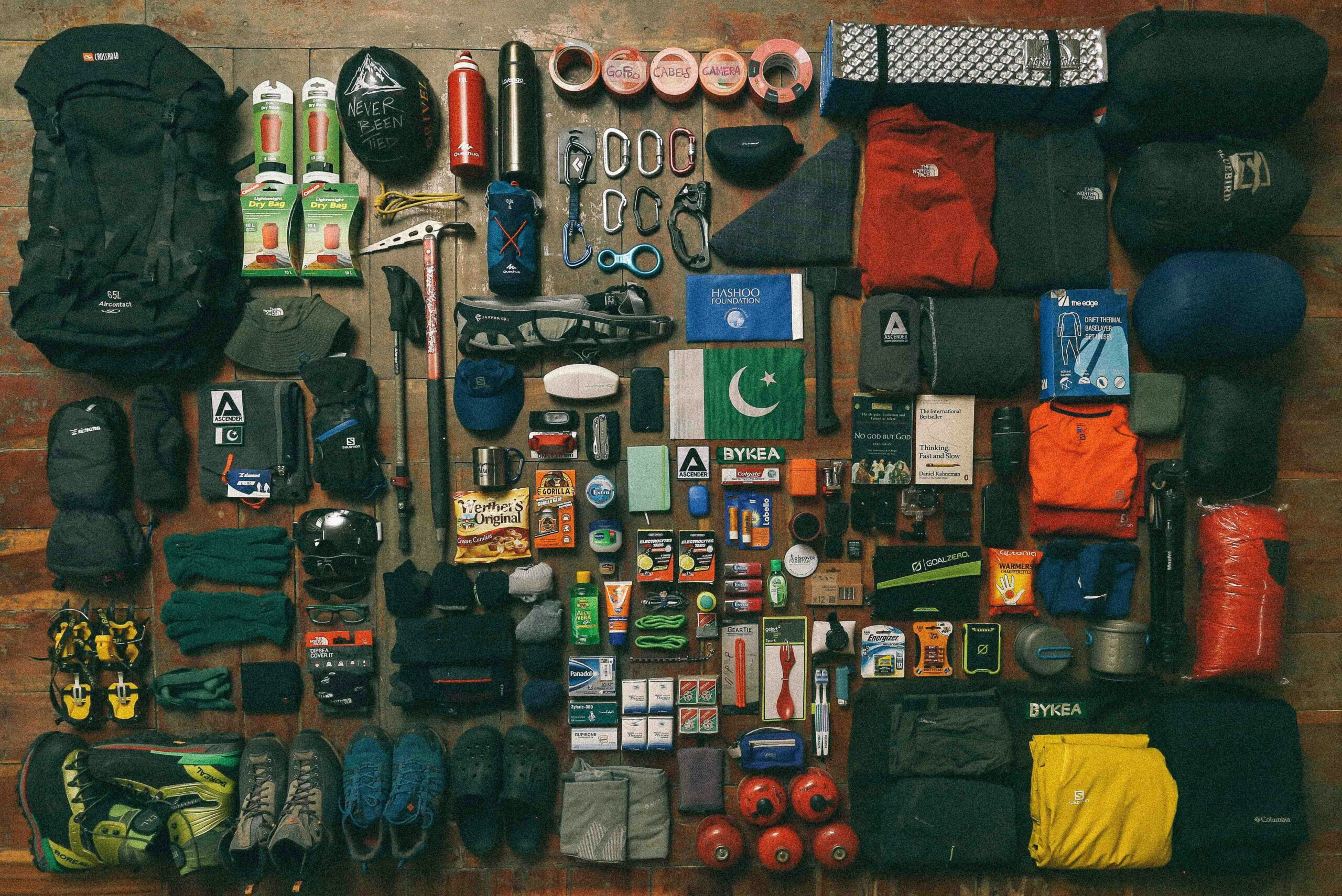 Holiday Gifts for Campers: 15 Perfect Ideas for Every Budget A neatly organized flat lay of hiking and mountaineering gear arranged on a wooden floor