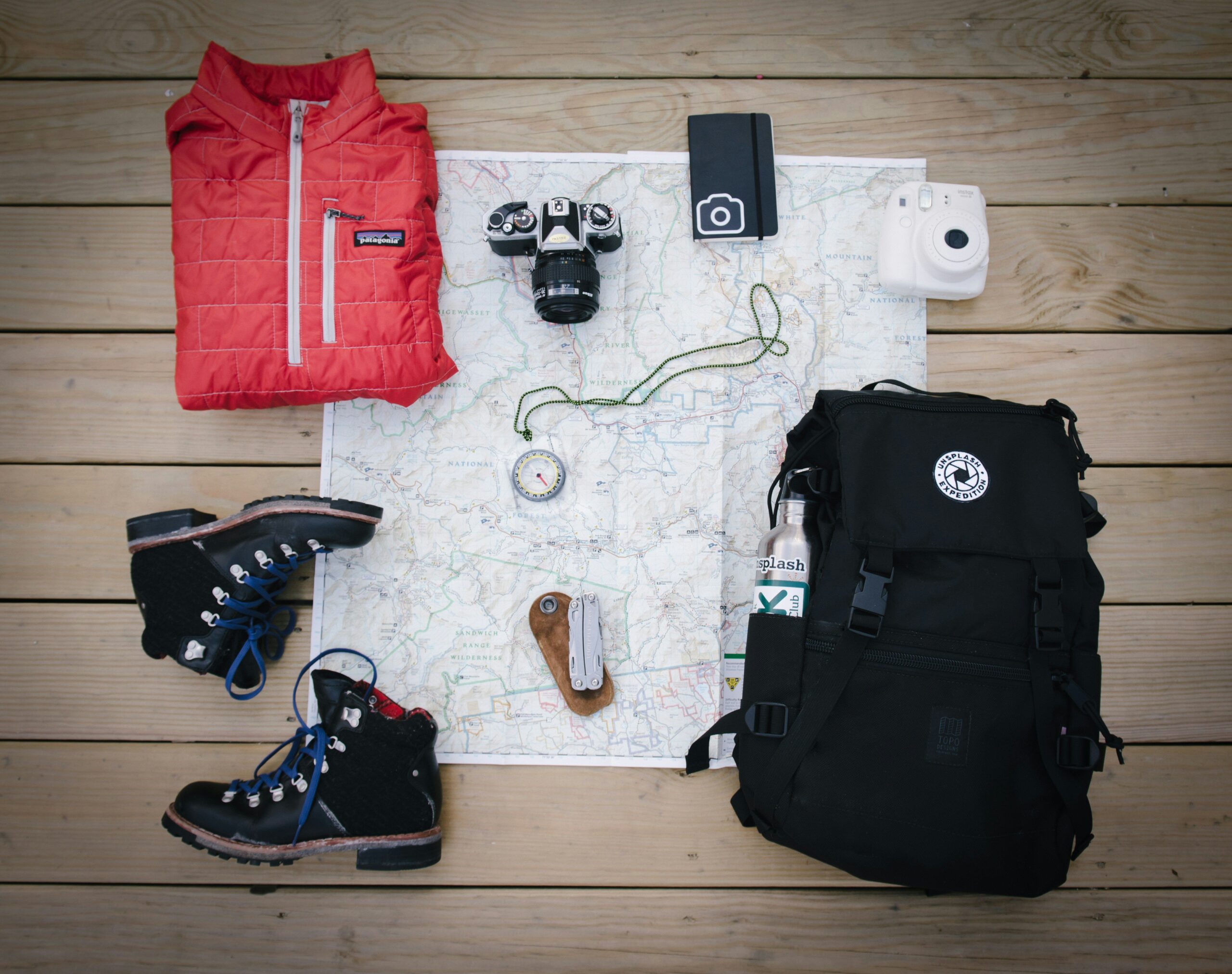 Holiday Gifts for Hikers: 15 Perfect Ideas for Every Budget A display of random hiking gear layed out on a wooden surface