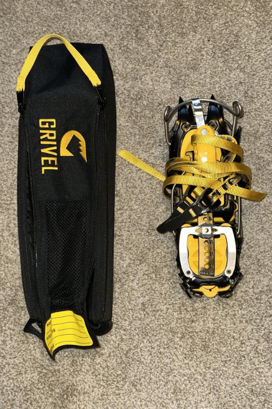 The Best 8 Crampons For Mountain Climbing Grivel G12 crampons packed up next to storage bag