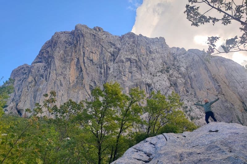 Camping For Beginners: 8 Tips For First Time Camping Trips Person in front of a nice view in nature. the cliffs of a mountain are in the background