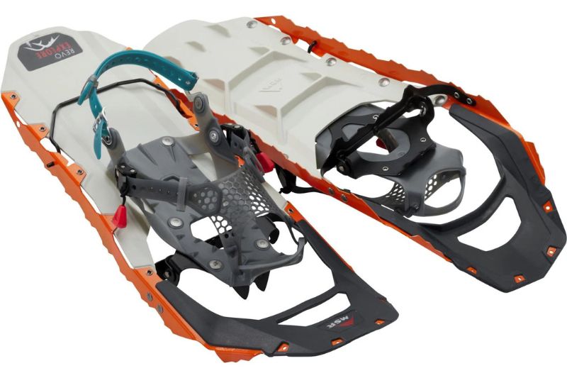 7 Best Snowshoes For Winter Hiking & Mountaineering A pair of modern, lightweight snowshoes with white frames and orange-trimmed edges. They feature black and gray bindings with blue adjustment straps for secure fitment.