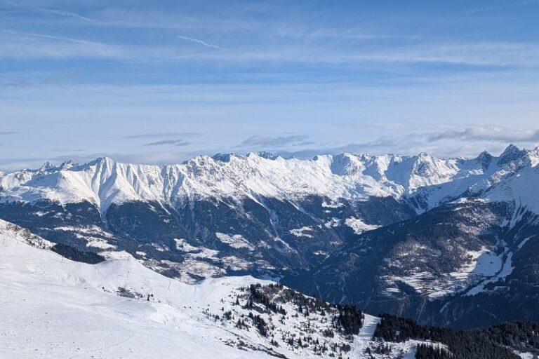 Altitude Sickness Guide: Symptoms & Prevention Mountain range that is covered in snow. The valley below that is at risk to avalanche is visible too.