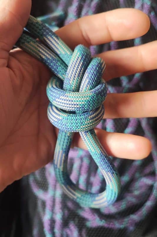 Essential Rope Skills & Knots for Mountaineering Example of the Overhand Knot made with a blue rope.