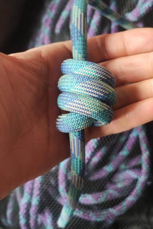 Essential Rope Skills & Knots for Mountaineering Example of the Stopper Knot made with a blue rope.
