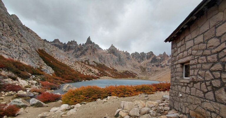 The Hiker's Guide to Backpack Hunting A stone hut in a rugged landscape with a lake