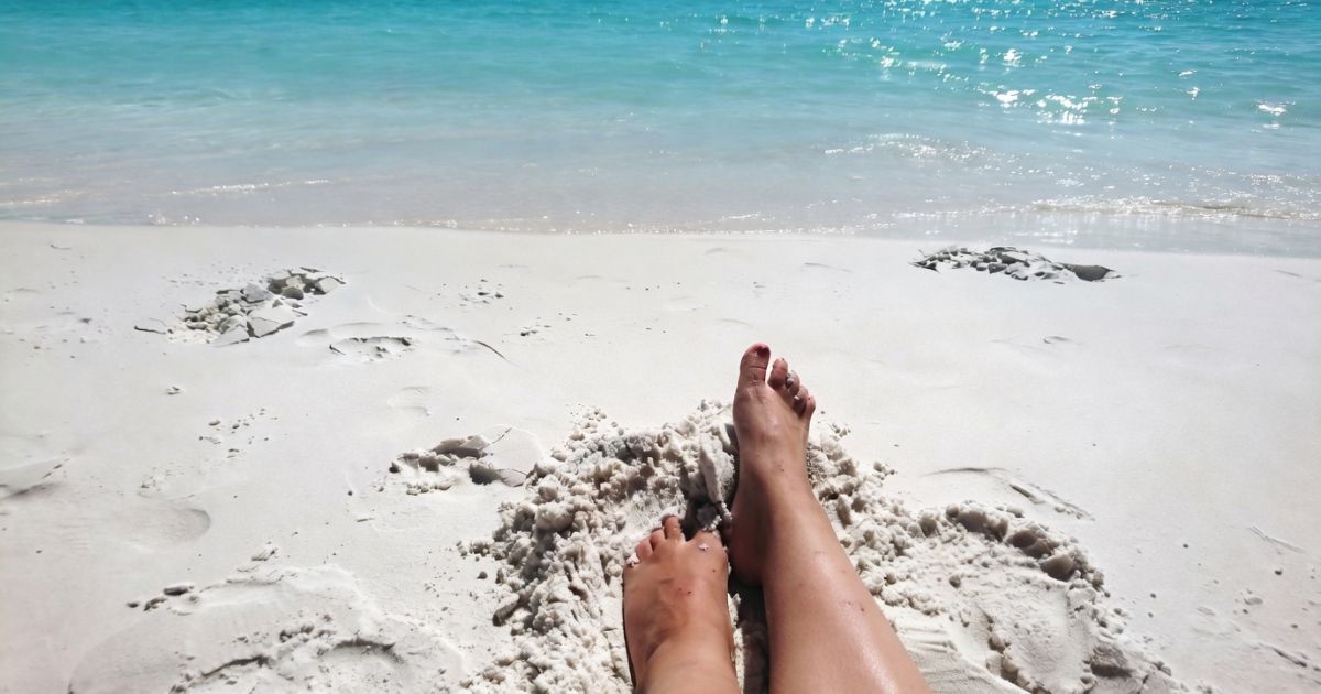 Hiking With Flat Feet: Expert Guide to Stronger Arches on the Trail Feet in the sand on the beach, near the water