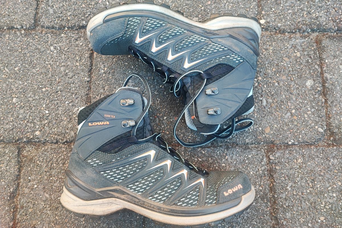 Lowa Innox Pro GTX Mid Review (2026 Test Results) a pair of Lowa Innox Pro Mid GTX laid out on their sides. The top one is placed upside down.