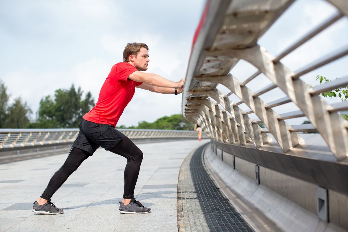 Hiker performing a calf and Achilles wall stretch to improve ankle mobility before hiking