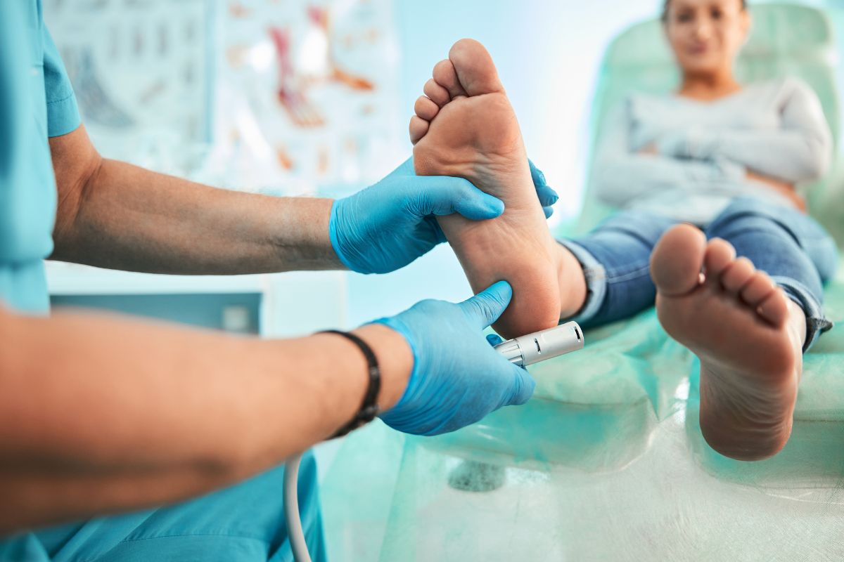 Podiatrist examining a patient's foot during an ankle assessment