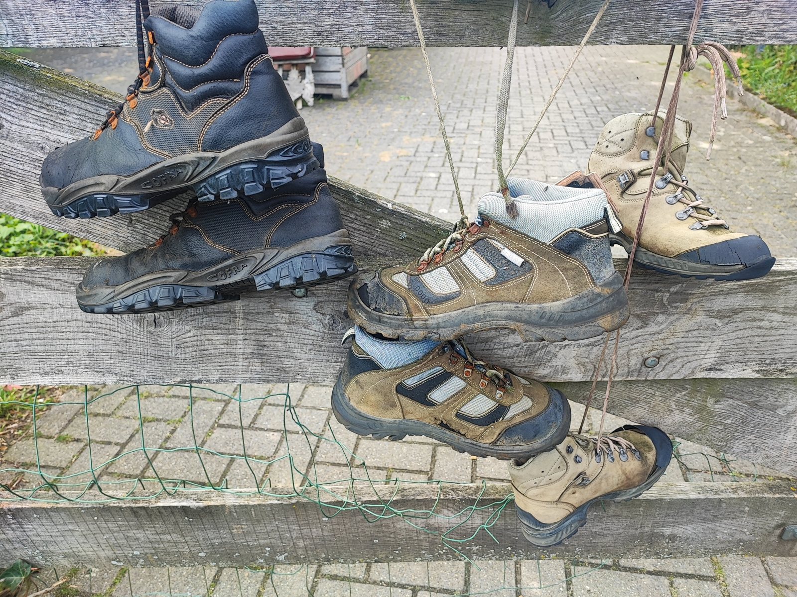 I Walked Four Days of the Pieterpad Without Booking a Single Bed Metal frame beside a paved path hung with dozens of worn-out hiking boots by their laces.