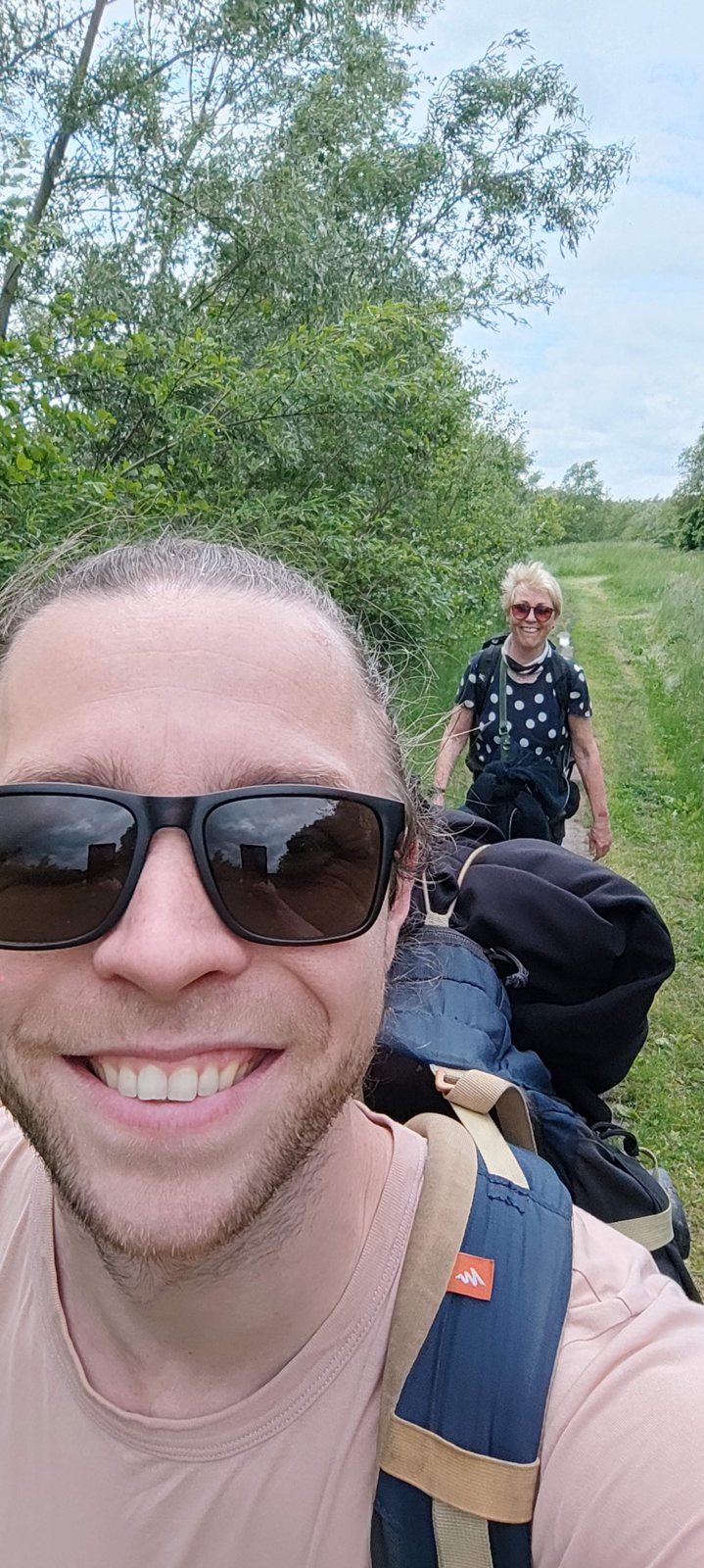 I Walked Four Days of the Pieterpad Without Booking a Single Bed Selfie of the author in sunglasses on a woodland trail with his mother walking behind him.