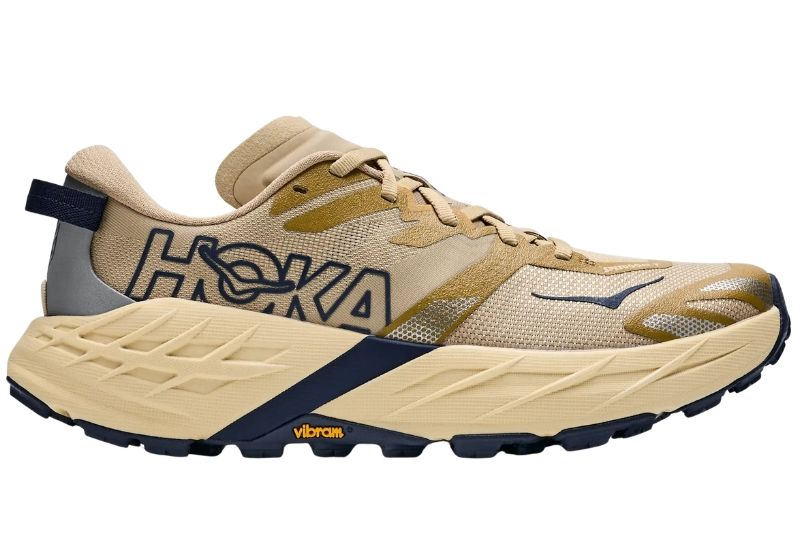 HOKA Speedgoat 7 trail shoe in tan with a navy outlined HOKA logo and Vibram outsole