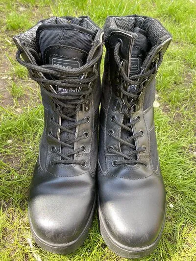 a pair of tactical boots sitting outdoor on the grass