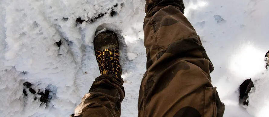 leg and feet of a man on the snow